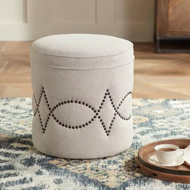 Pouf rotondo rivestito con borchie decorative